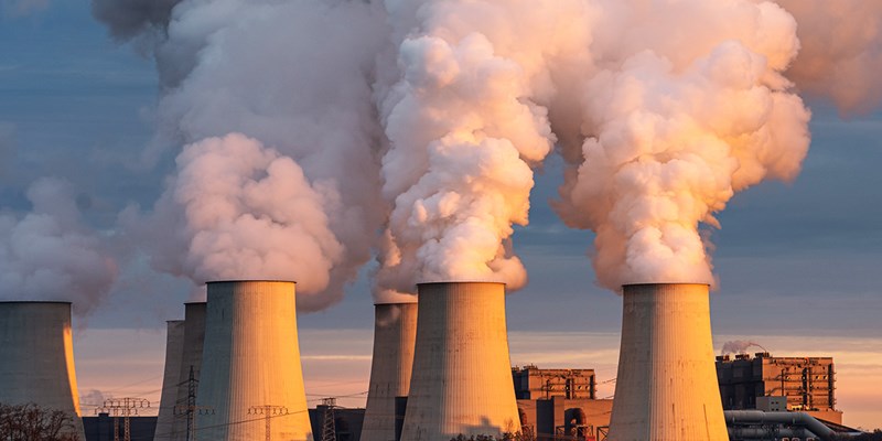 Smoking pipes of thermal power plant on sunset.